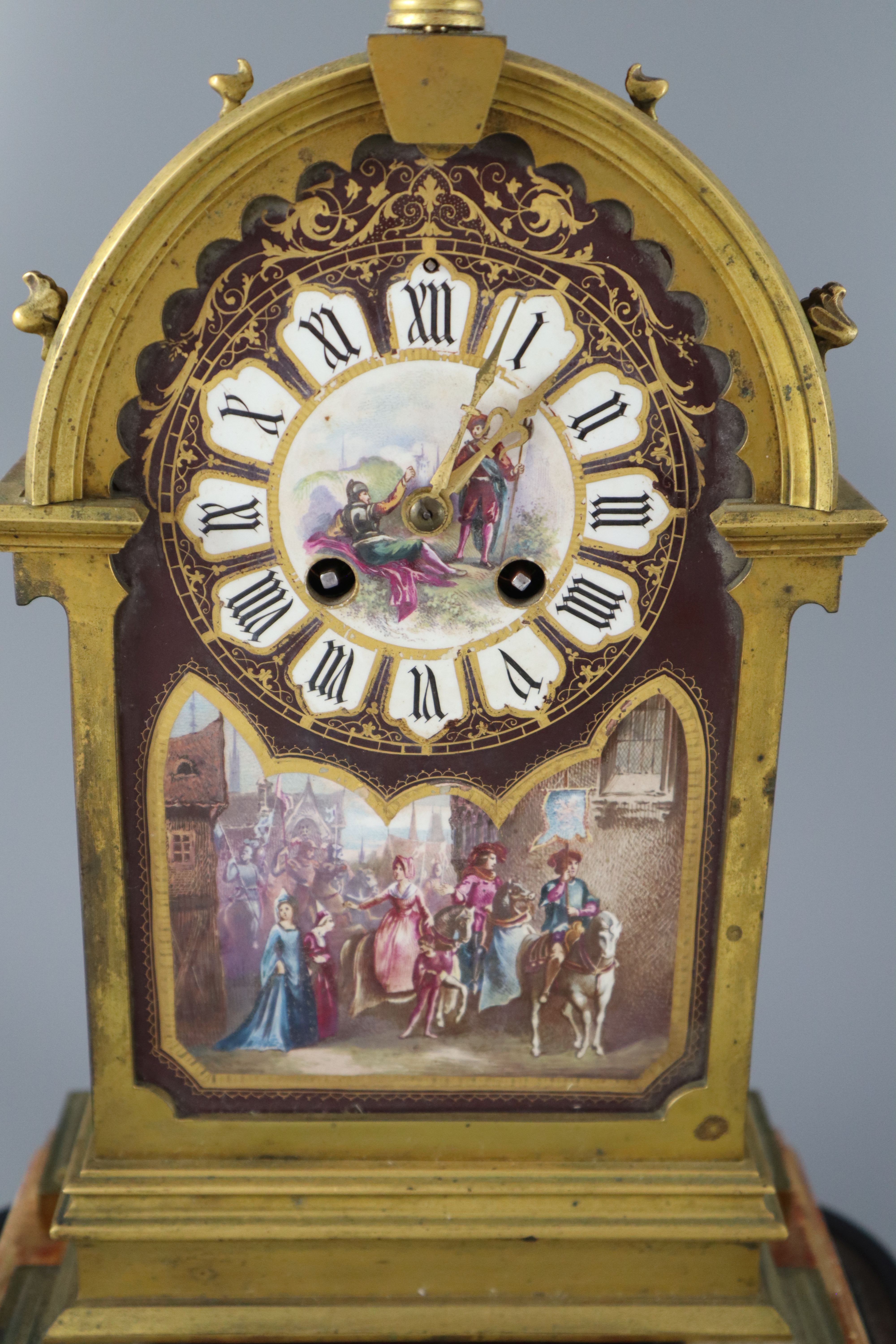 A 19th century French ormolu and enamelled porcelain clock garniture, clock height 13.75in. urns 11.5in. overall on both plinths 17in.